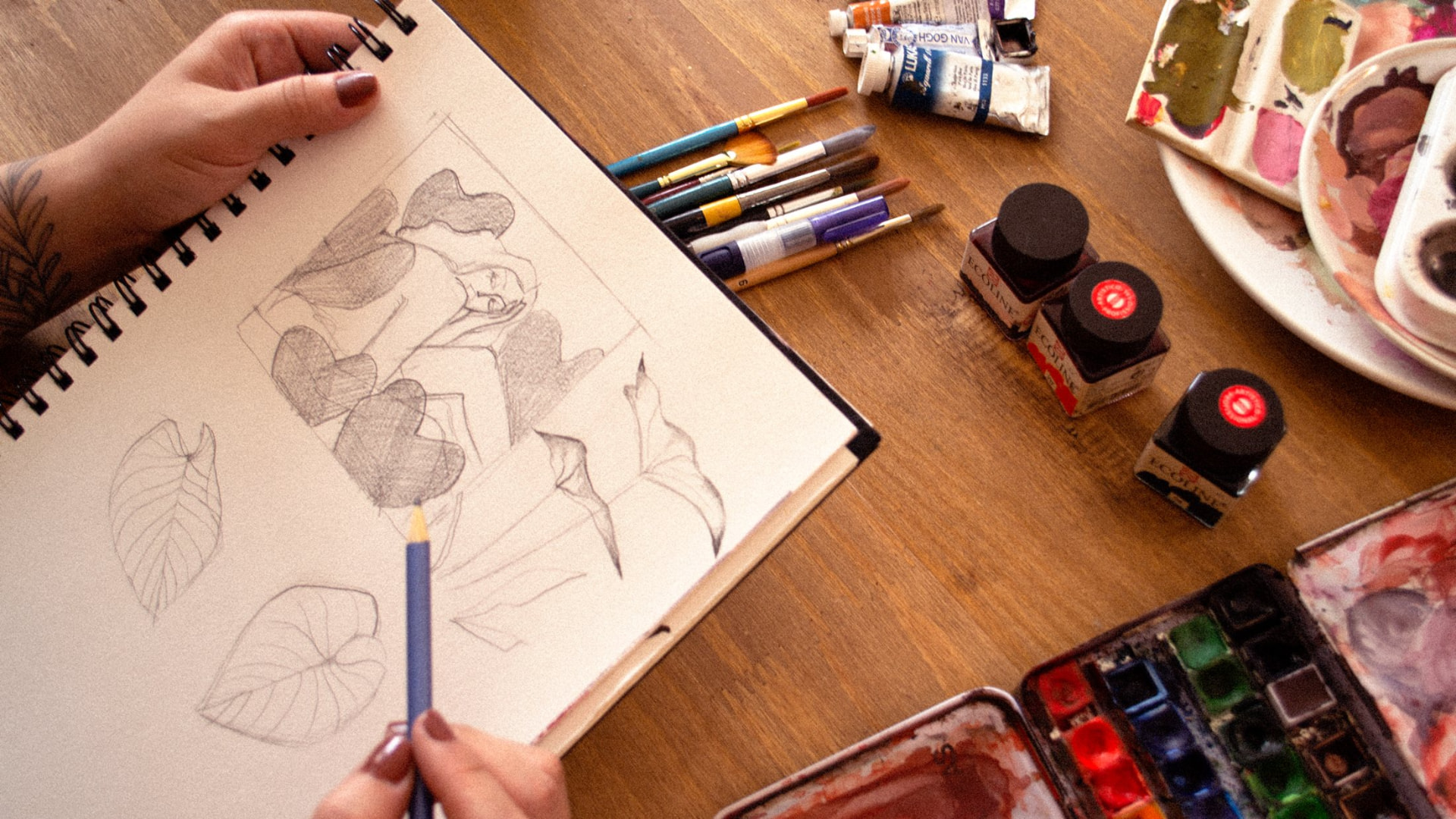 Mão desenhando um retrato a lápis no sketchbook
